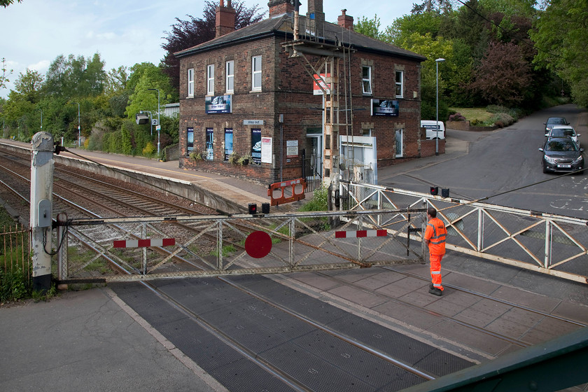 Closing crossing gates, Brundall Level Crossing 
 A scene that will be wiped away soon. With the imminent re-signalling of the lines west of Norwich, as well as the loss of the semaphores and boxes, the manual gates here at Brundall will also disappear. Here, dressed in the usual (and excessive?) full organge garb the gates are opened by the crossing keeper following the passage of the 14.17 Great Yarmouth to Norwich. 
 Keywords: Closing crossing gates, Brundall Level Crossing