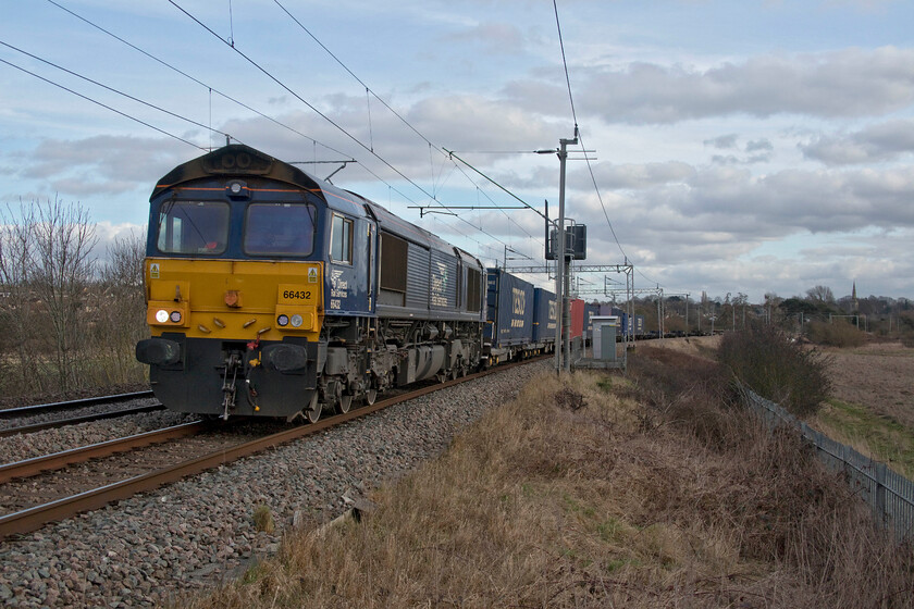 66432, 10.03 Tilbury-DIRFT (4M07, 19E), Wilson's crossing 
 DRS' 66432 climbs away from Northampton past Wilson's crossing with the very lightly loaded 4M07 10.03 Tilbury to Daventry (DIRFT) Tesco Express. Despite the large areas of blue sky above the train a huge mass of black cloud was being blown in from the northwest behind me that had obliterated the sun that had been out virtually all the day up until now when I was stuck at work off course! 
 Keywords: 66432 10.03 Tilbury-Dirft 4M07 Wilson's crossing DRS Direct Rail Services Tesco Express