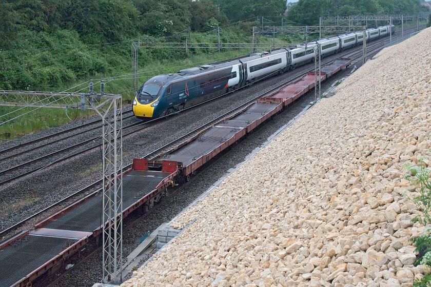 15.49 Garston-Dagenham (6L48, 4E) & 390114, VT 19.30 Birmingham New Street-London Euston (1B86, 7L), Ashton Road bridge 
 As the long tail of the 6L48 15.49 Gaston to Dagenham passes Ashton Road bridge near Roade the 19.30 Birmingham to Euston Avanti service overtakes it worked by 390114 'City of Manchester'. 
 Keywords: 15.49 Garston-Dagenham 6L48 390114 19.30 Birmingham New Street-London Euston 1B86 Ashton Road bridge Avanti West Coast Pendolino City of Manchester