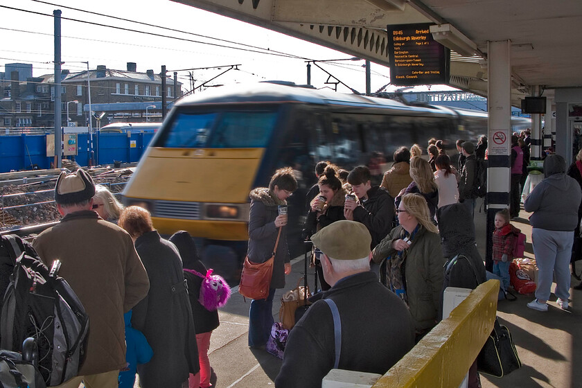 91121, GR 09.00 London King's Cross-Edinburgh Waverley (1S09), Peterborough station 
 A very bust scene at Peterborough station as the 1S09 09.00 King's Cross to Edinburgh service arrives at the station. My wife, son (seen centre right) and I travelled on this train all the way to Scotland enjoying the luxury and comfort of a Mk.IV coach. Incidentally, it may be the beginning of April but notice how people are dressed; it was extremely cold with a keen easterly wind blowing! 
 Keywords: 91121 09.00 London King's Cross-Edinburgh Waverley 1S09 Peterborough station EC East Coast IC225