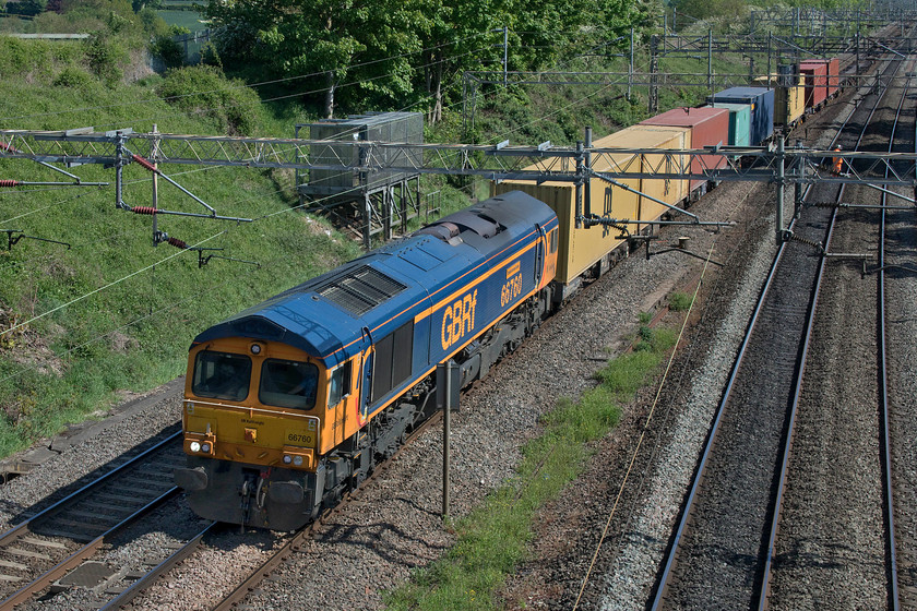 66760, 10.36 Felixstowe North-Hams Hall (4M23, 5E), Victoria bridge 
 A very lightly loaded 4M23 10.36 Felixstowe to Hams Hall passes Victoria bridge led by 66760 'David Gordon Harris'. Notice the track worker, part of a group involved in some somewhat half-hearted bank clearance, standing on the up fast line that has remained shut, along with the down fast, for the third week. 
 Keywords: 66760 10.36 Felixstowe North-Hams Hall 4M23 Victoria bridge David Gordon Harris GBRf