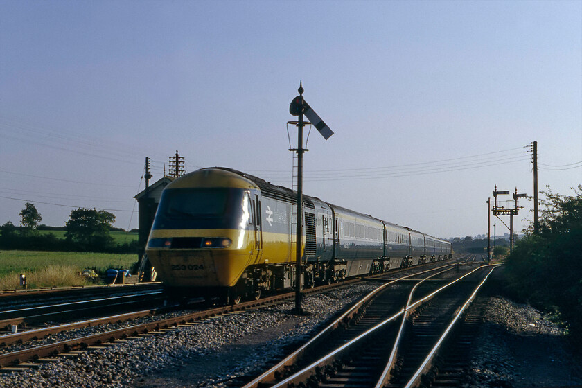 253024, 16.45 Plymouth-London Paddington, Witham 
 A photograph of dubious technical quality and composition! Firstly, the 253024 demonstrates some motion blur as it heads past Witham (Somerset) working the 16.45 Plymouth to Paddington HST service. Secondly, I am not too sure why I pressed the shutter with the HST almost obliterating the signal box, a second earlier placing it just in front of the home semaphore post would have been perfect! However, the summer evening lighting is superb and partially makes up for my schoolboy photographic errors! 
 Keywords: 253024 16.45 Plymouth-London Paddington Witham HST Class 43