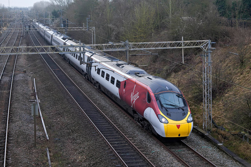 390016, VT 11.00 London Euston-Manchester Piccadilly (1H20, 14L), Victoria Bridge 
 The newly applied flying silk livery of 390016 really brightens up the dullness of a grey December day as it passes Victoria Bridge on the southern section of the WCML near Roade. It is working the 11.00 Euston to Manchester Piccadilly 1H20 that, unfortunately, arrived 14 minutes late. 
 Keywords: 390016 11.00 London Euston-Manchester Piccadilly 1H20 Victoria Bridge