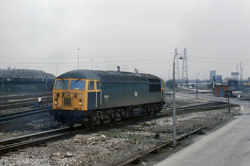 56058, coming off-shed, Toton Yard 
 By the side of the entrance road to Toton depot was a small flat-roofed building that I climbed on to. This provided me with a superb vantage point where I spent some time taking pictures. 56058 comes off the depot ready for its next job. Prominent in the background to the left is the famous 'Toton bank'. This fabled spot is still accessed today by many photographers providing an impressive vista of the depot and roads. 
 Keywords: 56058 off-shed Toton Yard