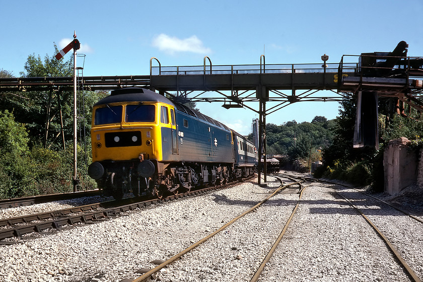 47473, 08.25 London Paddington-Penzance, Stoneycombe Quarry 
 47473 leads the 08.25 Paddington to Penzance service past Stoneycombe Quarry on the ascent of Dainton bank with the summit some mile and half away. This view reveals the up home signal controlled by Stoneycombe Sidings signal box that was permanently switched out at this time probably only being manned when a train moved in or out of the sidings to the right. By this time, there were very few train movements associated with the quarry witnessed by the rusty railheads despite some loaded twenty-four ton 'Dogfish' wagons seen in the distance. The stone conveyor and loading chute have only very recently been removed as it still appears on the latest Ordnance Survey map but has gone when looking at Google Earth with the latter still clearly showing the signal box as seen in the previous photograph. Notice the unusual arrangement of the domino headcode dots on this end of the Class 47 with the left hand one being somewhat out of position! 
 Keywords: 47473 08.25 London Paddington-Penzance Stoneycombe Quarry