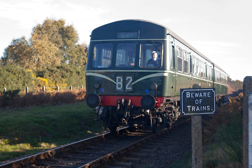 M51192 & M56352, 09.55 Sheringham-Holt, Kelling Heath 
 Class 101 DMU formed of M51192 and M56352 brings the first train of the day, the 09.55 Sheringham to Holt, across Kelling Heath. The picture is taken from a busy crossing on the heath. Notice the reproduction (?) cast sign. 
 Keywords: M51192 M56352 09.55 Sheringham-Holt Kelling Heath