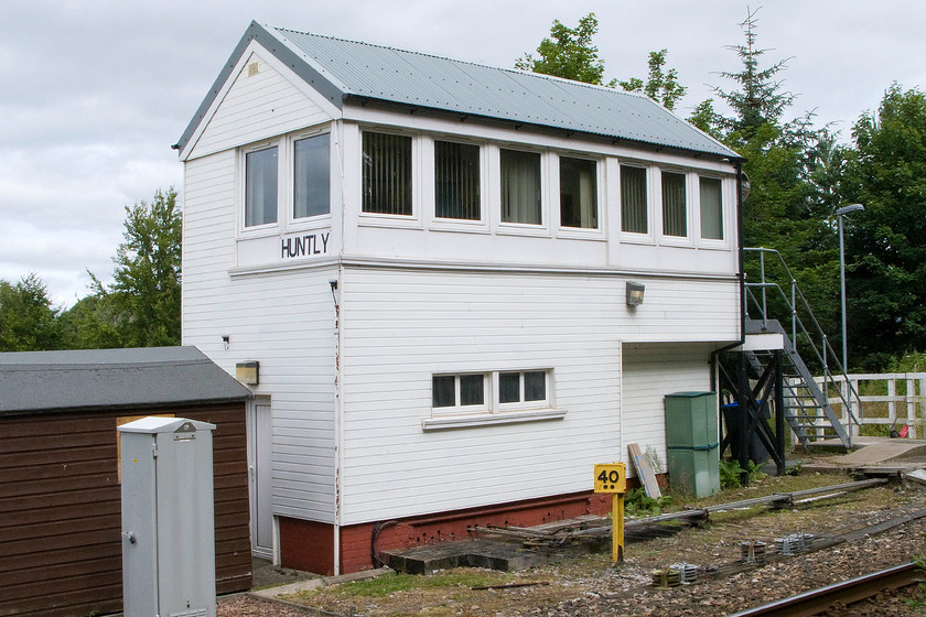 Huntly (South) signal box (GNS, 1890) 
 With the milepost showing forty and a half miles from Aberdeen, Huntly signal box is seen in its full UPVC glory! Until it was 'improved' it was typical compact Great North of Scotland wooden structure dating from 1890 being effectively a mini version of Elgin central, see..... https://www.ontheupfast.com/p/21936chg/28943039604/elgin-centre-signal-box-gns-great It used to be named Huntley South but was renamed when the identical north box was closed following the singling of the line in 1970. Despite the recent work undertaken the box is facing closure in the next couple of years with the resignalling of the line between Inverness and Aberdeen. 
 Keywords: Huntly South signal box Great North of Scotland railway GNS