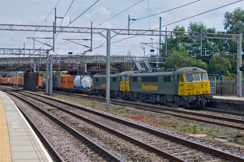 86628 & 86605, 10.10 Tilbury-Crewe Basford Hall (4M54), Lichfield Trent Valley station 
 I was not in quite the right spot to capture the 4M54 10.10 Tilbury to Crewe Basford Hall Freightliner service as it passes on the down slow line through Lichfield station. The train is being led by two of Freightlioner's classic Class 86s (86628 & 86605) that are no strangers to this route with them once leading fast electric express services prior to their demotion. It is likely that over the coming few years that these locomotives will be replaced by more modern machines. 
 Keywords: 86628 86605 10.10 Tilbury-Crewe Basford Hall 4M54 Lichfield Trent Valley station Freightliner