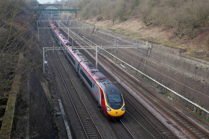 390128, VT 10.00 Glasgow Central-London Euston (9M53), Roade Cutting 
 As the afternoon sun just begins to brighten the scene a little, 390128 'City of Preston' passes south through Roade Cutting working the 10.00 Glasgow Central to Euston. This picture clearly illustrates the significant extra length of these eleven-car Pendolinos with the rear of the train having not even passed under the green painted aqueduct 
 Keywords: 390128 10.00 Glasgow Central-London Euston 9M53 Roade Cutting