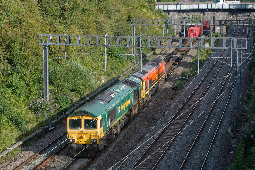 66593 & 66508, 12.57 London Gateway-Garston (4M56, 17L), Hyde Road bridge 
 Having seen the southbound 4L90 triple-headed a short time earlier the northbound 4M56 is double-headed! I am not sure why the 12.57 London Gateway to Garston was being led by 66593 '3MG Mersey Multimodal Gateway' and 66508 with just the leading locomotive under power. As the train had run on time from the start I suspect failure was not the issue but rather it was a logistical move to return 66508 perhaps to Freightliner's depot at Crewe where the train had a lengthy and scheduled layover. The train is seen passing Roade from the village's Hyde Road bridge. Thanks to Mike and Freightmaster for identifying the trailing Class 66 whose number could not be seen from the photograph. 
 Keywords: 66593 66508, 12.57 London Gateway-Garston 4M56 Hyde Road bridge Freightliner 3MG Mersey Multimodal Gateway