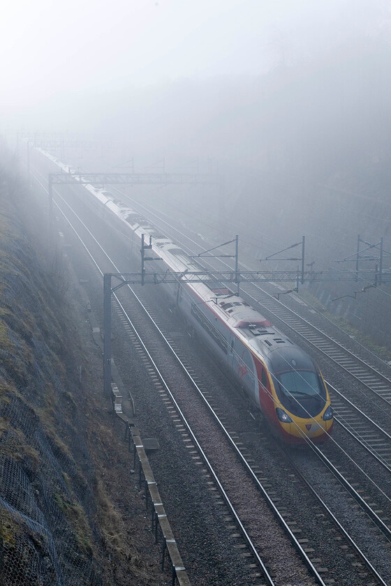 Class 390, VT 09.45 London Euston-Glasgow Central, Roade cutting 
 Having been in service on the WCML for just over ten years now the Class 390 Pendolinos have proved to be dependable whisking passengers up and down the length of the line. An unidentified member of the class passes through Roade working the 09.45 Euston to Glasgow Central. The train is on the down slow line taking a Sunday diversion through Northampton rather than via the Weedon 'old route'. 
 Keywords: Class 390 09.45 London Euston-Glasgow Central Roade cutting Virgin Pendolino