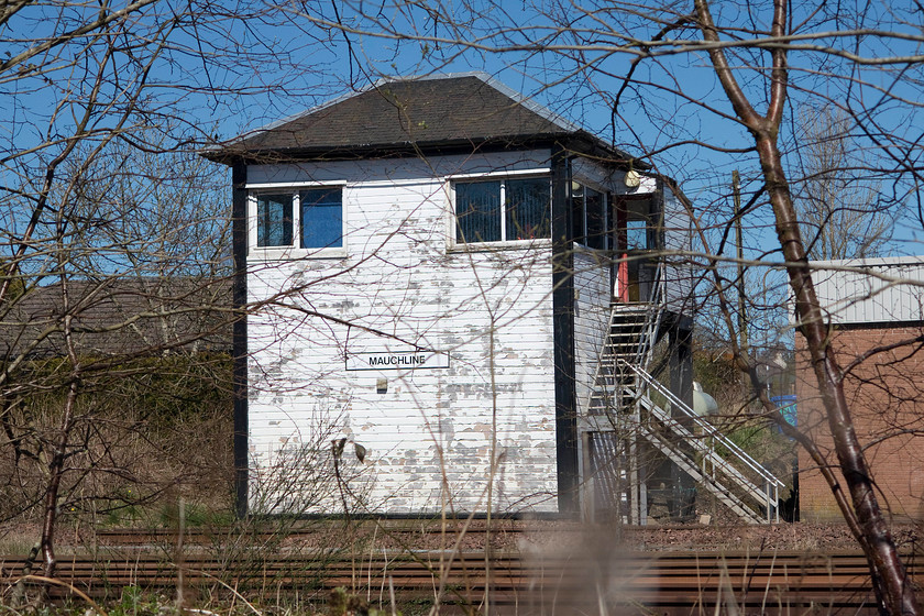 Mauchline signal box (GSW, 1877) 
 I persuaded my boss to make a small diversion even though we had a pretty major journey ahead of us in a 2002 Rover 45! After parking in a cemetery car park and walking across a field this was the best shot that I could secure of Mauchline signal box. The box is on the Glasgow and South Western Railway trunk route that runs from Carlisle up to Glasgow via Dumfries. The box was originally designated as Number One with the other one closing in 1970 at the same time that the Newton-on-Ayr line was singled. It is built to the GSW's in-house design and was opened in 1877. 
 Keywords: Mauchline signal box