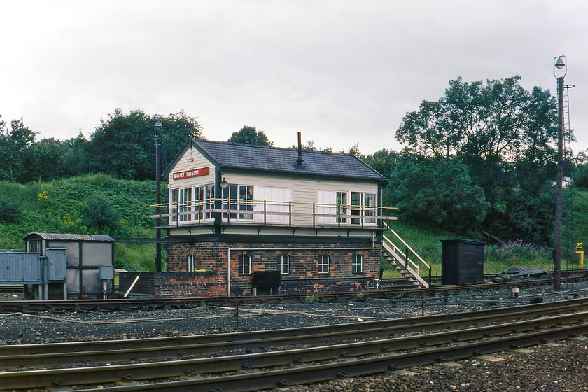 Market Harborough signal box (LNWR, date U K) 
 Formally named Market Harborough Number Three signal box is seen from the platform end of the station. It's an interesting anomaly that the former LNWR box is actually controlling the Midland route to the north end of Harborough station. There used to be two Midland boxed (One and Two) located here but they were taken out use as various rationalisations took place hence this one remaining. Notice its wooden name board has had the No. 3 removed and painted over. The lines behind the box are the former LNWR to Northampton that closed almost a year from the day that I took this photograph. 
 Keywords: Market Harborough signal box