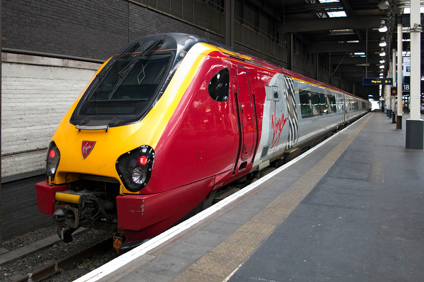 221112, VT 11.10 London Euston-Chester (1D85, 2E), London Euston station 
 221112 'Ferdinand Magellan' stands at London Euston's platform 18 ready to work the 11.10 departure to Chester. This far western side of the station is not a very pleasant area being composed of huge slabs of flat concrete and with a higher roof. However, this does allow for the diesel fumes from these class 221s to dissipate more than when they are left idling towards the centre of the station where it is more confined. 
 Keywords: 221112 1D85 London Euston station