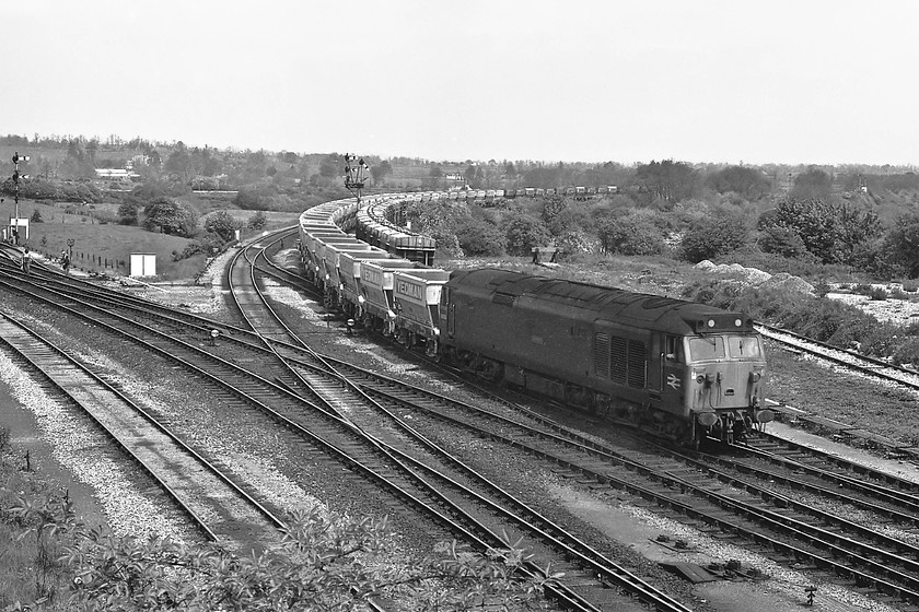 50033, down Foster Yeoman empty stone working, Westbury North 
 Foster Yeoman stone workings were a very common sight at Westbury with trains coming and going from their Mendip quarries. However, to find a class 50 on such trains was not common, they were usually handled by class 47 and class 37 locomotives. Here, taken from the road bridge just before the station at Westbury, 50033 'Glorious' brings an empty wagon working in from the east, probably originating from the London area. Notice the line of twenty ton Presflo discharge wagons in the adjacent sidings associated with the nearby cement works that is just out of view to the right. 
 Keywords: 50033 Foster Yoeman empty stone working, Westbury North