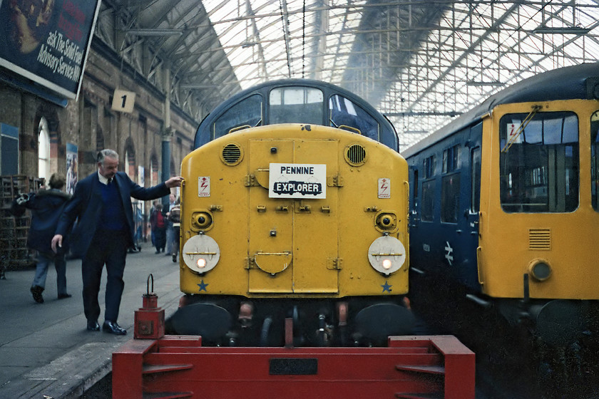 40024, outward leg of the Pennine Explorer, Cardiff Central-Rotherwood, Manchester Piccadilly station 
 As were swapping our English Electric class 40 for a 1500v class 76 we came into platform 1 at Manchester Piccadilly that was electrified with the appropriate wires rather than the more usual 25kv. The driver of 40024, steps down from the cab in order to retrieve the headboard whilst all the attention was at the other end of the train. Notice the large advertising hoarding for the Solid Fuel Advisory Service. In the 1970s the SFAS was part of the nationalised National Coal Board. Whilst the organisation still exists today, it is a private organisation that seeks to promote the use of solid fuels to heat our homes, with a great emphasis on the use of wood-burners rather than on coal in 1978. 
 Keywords: 40024 Pennine Explorer Cardiff Central-Rotherwood Manchester Piccadilly station