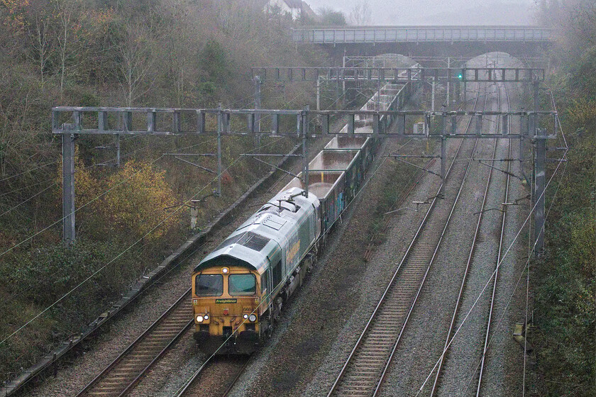 66610, 13.20 Willesden-Tunstead Sidings (6H50, 3E), Hyde Road bridge 
 Festooned with stone dust and with a rust-stained front end, Freightliner's 66610 looks a bit of a mess as it passes through Roade taken from Hyde Road bridge. The Class 66 is working the 13.20 Willesden to Tunstead Sidings empty stone train running as 6H50. This is a regular operation on the WCML in association with the construction of HS2 and makes a change from the usual intermodal and box train fare! 
 Keywords: 66610 13.20 Willesden-Tunstead Sidings 6H50 Hyde Road bridge Freightliner