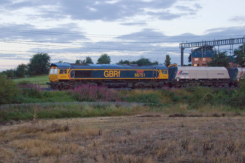 66751, 23.18 Peak Forest Cemex-Bletchley Cemex (6B10, 83L), between Roade & Ashton 
 Another train that I do not very often photograph due in large part to it running through the night is the 23.18 Peak Forest to Bletchley loaded stone train. The 6B10 train is seen crawling south near Roade within the last few miles of its destination with 66751 'Inspiration Delivered Hitachi Rail Europe' at the head. Time to head home across the filed and have some breakfast! 
 Keywords: 66751 23.18 Peak Forrest Cemex-Bletchley Cemex 6B10 between Roade Ashton GBRf