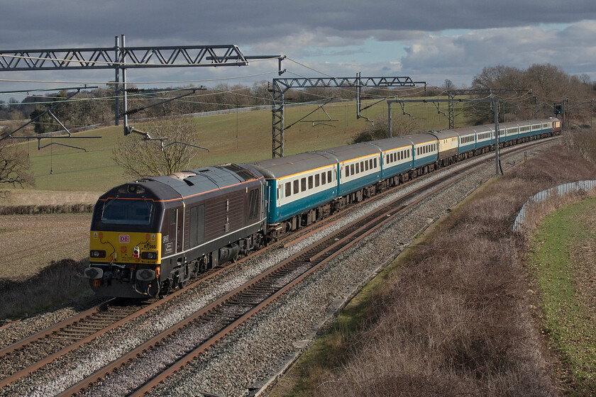 67005 & 67024, 08.43 Newcastle Central-Wembley Central (1Z43, 6L), Milton crossing 
 When the subject is interesting and the weather this good I will take a 'going-away' shot quite happily! 67005 'Queen's Messenger' brings up the rear of the 08.43 Newcastle Central to Wembley Central footex as it passes Milton Crossing between Roade and Blisworth. The train was running just under half an hour late by this point following an unexplained pause a short distance north at Hillmorton Junction. A fellow enthusiast on the bridge here indicated that the driver had stopped the train due to a brake dragging issue following its reversal at Nuneaton. The football fans on board did not miss the start of their Carabao Cup final at Wembley but the result did not go their way - Newcastle losing 2-0 to Manchester United. 
 Keywords: 67005 67024 08.43 Newcastle Central-Wembley Central 1Z43 Milton Crossing Queen's Messenger