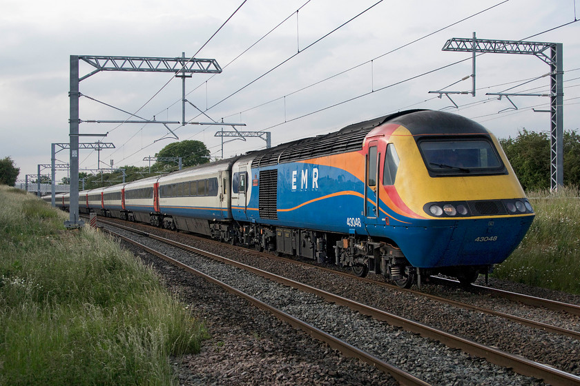 43048, EM 17.44 Nottingham-London St. Pancras (1B69, 10E), Irchester SP927667 
 With just a hint of the sun on the side of the 17.44 Nottingham to St. Pancras as it passes Irchester the grey sky somewhat dominates! EMR's 43048 'T.C.B. Miller OBE' power car leads the train as it commences the climb to Sharnbrook summit (338 feet from 130). This set was entirely composed of EMR stock rather than ex LNER stock and power cars that have recently entered service on the MML. 43048 started off its life as a Valenta engined power car on the Western Region as part of set 253024. When it is withdrawn very soon from service it is to be donated by Porterbrook to the 125 Group. 
 Keywords: 43048 17.44 Nottingham-London St. Pancras 1B69 Irchester SP927667 East Midlands Railway EMR HST T.C.B. Miller OBE