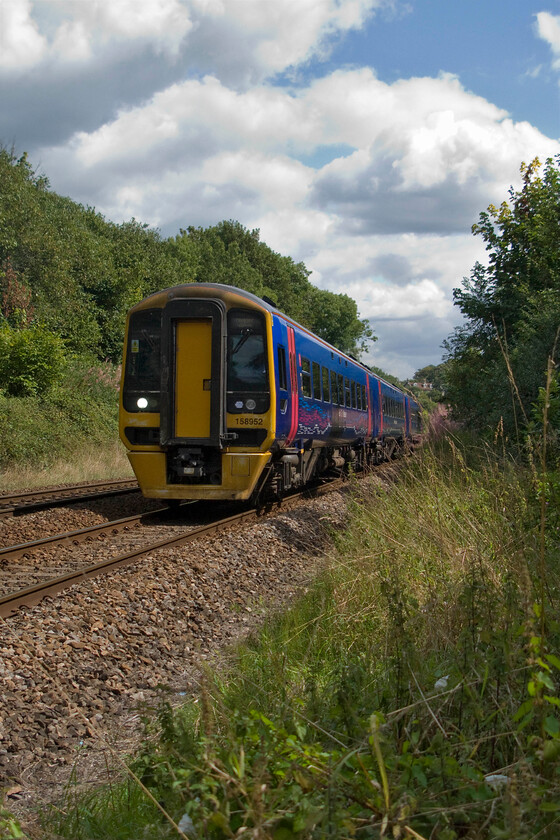 158952, GW 10.23 Portsmouth Harbour-Cardiff Central (1F14), Bradford-on-Avon number 2 crossing 
 Revisiting this location some forty years on from when I did as a schoolboy spotter back in the 1970s has revealed how the rampant growth of lineside vegetation has completely changed it. It used to be the case that the bank to the right was completely clear of growth enabling photographs to be taken from it, for example, see.. https://www.ontheupfast.com/p/21936chg/25511222404/x47055-parcels-bradford-avon-foot In this 2014 view looking the other direction 158952 leaves Bradford-on-Avon working the 10.23 Portsmouth Harbour to Cardiff Central. 
 Keywords: 158952 10.23 Portsmouth Harbour-Cardiff Central 1F14 Bradford-on-Avon First Great Western