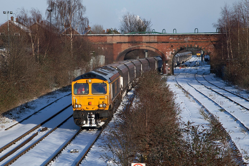 66751, 12.00 Drax-Tyne Coal Yard (4N61), Knottingley station 
 As the afternoon shadows lengthen 66751 'Inspiration Delivered Hitachi Rail Europe' proceeds through Knottingley station with the late running 12.00 Drax to Tyne Coal Yard empty Biomass working. 66063 can be seen stabled in the background waiting for permission to make its light engine move to Milford Sidings. 
 Keywords: 66751 4N61 Knottingley station