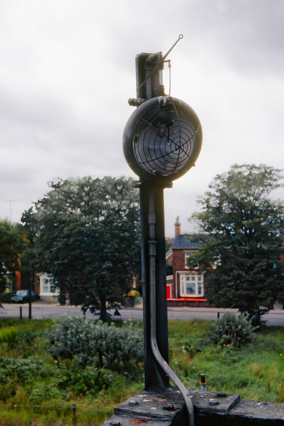 Disused gas lamp, footbridge, Spalding 
 Situated on a footbridge that spanned the lines to the north of Spalding station was this gas lamp. I suspect that this particular example was a replacement for an earlier and far more ornate type that would have burnt town gas. However, this slightly later example would probably have burnt LPG either from the mains supply or from a cylinder located safely nearby. I also think that at the time that this photograph was taken that the lamp had fallen out of use but it does appear to have an intact mantle in front of the reflector disk. 
 Keywords: Disused gas lamp footbridge Spalding