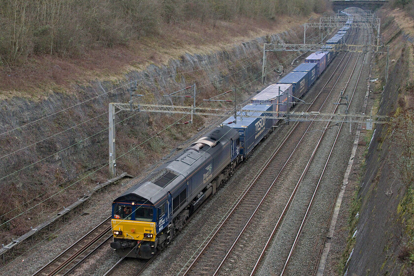 66122, 08.02 Tilbury-DIRFT (4M07, RT), Roade cutting 
 Passing through Roade cutting the down 'Tesco Express' is seen led by DRS' 66122. With recent terrorist activity in the Gulf of Aden and shipping having to take lengthy diversions around Africa Tesco will be one of the many corporations affected meaning that trains such as 4M07 may become less frequent in the short term. 
 Keywords: 66122 08.02 Tilbury-DIRFT 4M07 Roade cutting