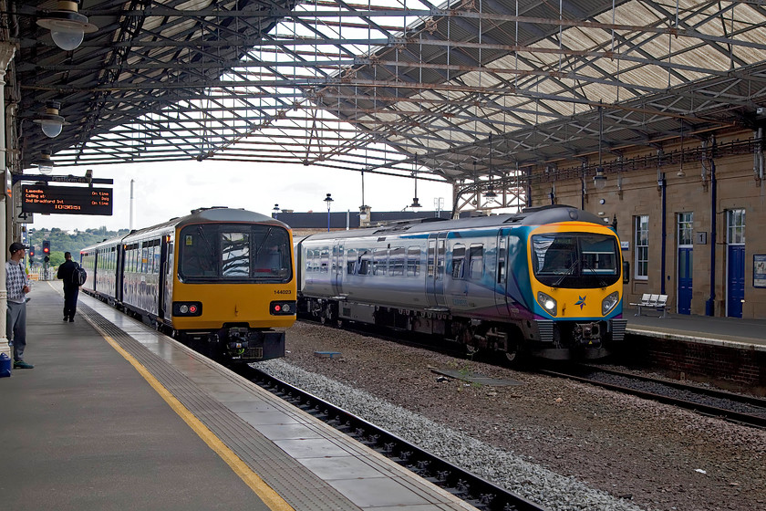 144023, NT 10.59 Huddersfield-Leeds (2J18, 2L) & 185119, TP 09.55 York-Manchester Airport (1P25, 7L), Huddersfield station 
 144023 sits at platform 4a of Huddersfield station about to leave with the 10.59 to Leeds. Meanwhile, 185119 is arriving at platform one with the 09.55 York to Manchester Airport. 
 Keywords: 144023 2J18 185119 1P25 Huddersfield station