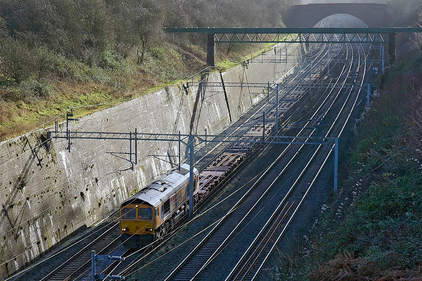 66703, 10.48 Wembley-Long Marston (6Z66), Roade cutting 
 66703 'Doncaster PSB 1981-2002' rambles through Roade cutting leading an empty line of Freightliner flats. The wagons are being taken to Long Marston as the 6Z66 10.48 from Wembley yard. The reason for their trip was for them to be repaired and overhauled at the increasingly busy and crowded facility just south of Stratford-on-Avon. 
 Keywords: 66703 10.48 Wembley-Long Marston 6Z66 Roade cutting Doncaster PSB 1981-2002