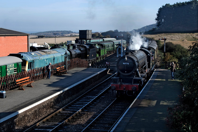 90775, 10.30 Sheringham-Holt, Weybourne station 
 With a busy Weybourne yard in the background, 1943 built ex. War Department 2-10-0 90775 'The Royal Norfolk Regiment' arrives into the station with the 10.30 Sheringham to Holt working. 
 Keywords: 90775 10.30 Sheringham-Holt Weybourne station