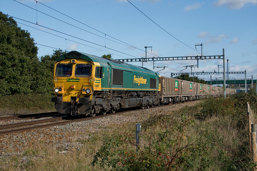 66607, 12.49 Appleford-Whatley Quarry (6C48, 2E), Uffington SU306904 
 Having sat in the Challow loop about five miles east of this spot for nearly an hour 66607 gets the 12.49 Appleford to Whateley Quarry empty stone working up to speed again. Running a Class 6 means that 6C48 will have a maximum speed of sixty miles per hour. which should be enough to keep out of the way of IET services until Swindon or even Thingley Junction (Chippenham) where it will leave the GWML. Along with March and April, I find the quality of light with the sightly lower angle of the sun particularly good at this time of year with a slightly warmer hue evident in many photographs with this one being a good example. I hope that Andy's photograph was as pleasing as this one; he was standing on the large and new footbridge in the background. 
 Keywords: 66607 12.49 Appleford-Whatley Quarry 6C48 Uffington SU306904 Freightliner