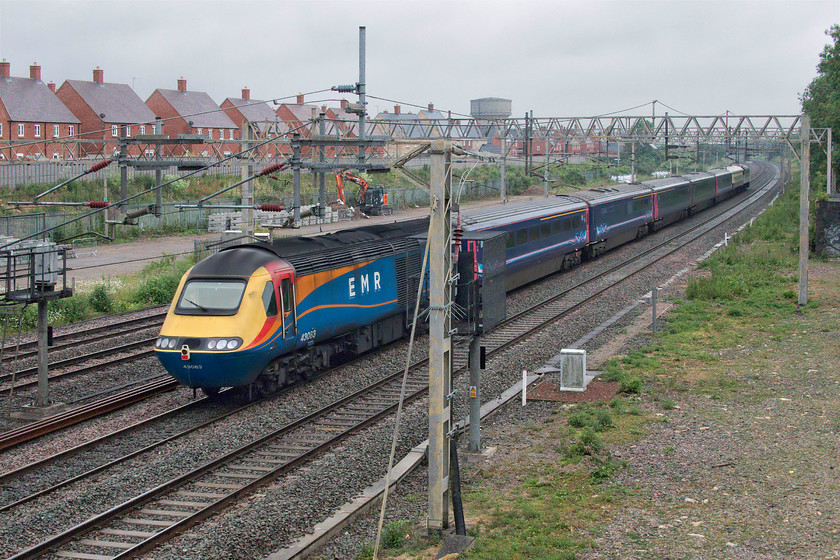 43083 & 47712, 07.14 Crewe HS-Eastleigh Arlington (5Z36, 2L), site of Roade station 
 I don't like taking 'going-away' photographs and this one clearly shows why! I have positioned the trailing power car 43083 badly between the two signalling posts but as the movement of an HST, with the exception of the NMT, on the WCML, even if it is dead in tow, is so rare it has made the cut. Along with five former Great Western Railway Mk.IIIs 44078, 40801, 46006, 40802, 46014 and Mk.I 5366 the HST combo is seen passing the site of Roade station as the 5Z36 07.14 Crewe to Eastleigh Arlington hauled by 47712 'Lady Diana Spencer'. Now running some thirty-five minutes early the train ran fast all the way to Ledburn Junction where it was moved to the slow to continue its journey south towards London. 
 Keywords: 43083 47712 07.14 Crewe HS-Eastleigh Arlington 5Z36 site of Roade station EMR East Midlands Railway GWr Great Western Railway HST Mk. III Lady Diana Spencer