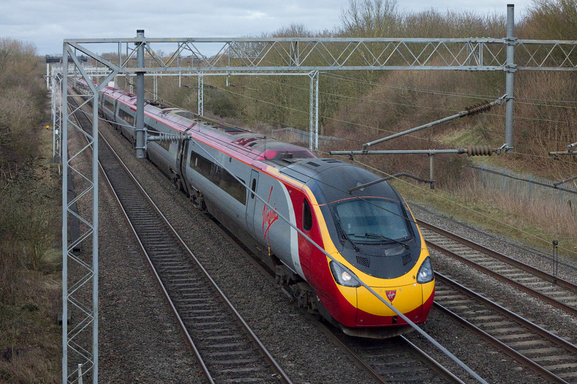 Class 390, VT 11.07 Wolverhampton-London Euston (1B13, 6E), Bradwell SP831391 
 The Sunday 11.07 Wolverhampton to London Euston slows as it approaches Milton Keynes past Bradwell just north of the station. There are very limited opportunities to take pictures in the Milton Keynes area as all the lineside is now smothered by palisade fencing and there are very few over-bridges that afford a decent view. 
 Keywords: Class 390 Pendolino 1B13 Bradwell SP831391