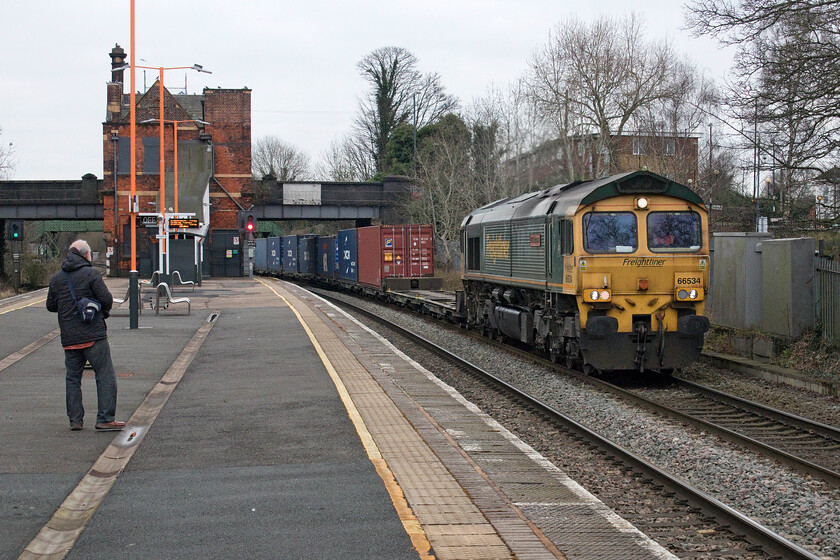 66534, 06.04 Leeds FLT-Southampton MCT (4090, 7E), Water Orton station 
 Having taken his photograph Andy observes 66534 'OOCL Express' eager to get its number as it passes through Water Orton station. The Freightliner Class 66 was leading the 4090 Leeds FLT to Southampton service on this very grey and chilly March morning. Andy and I had been on the desolate platforms of Water Orton station for getting on for an hour by this time and we were now looking forward to going for some breakfast! 
 Keywords: OOCL Express 66534 06.04 Leeds FLT-Southampton MCT 4090 Water Orton station Freightliner