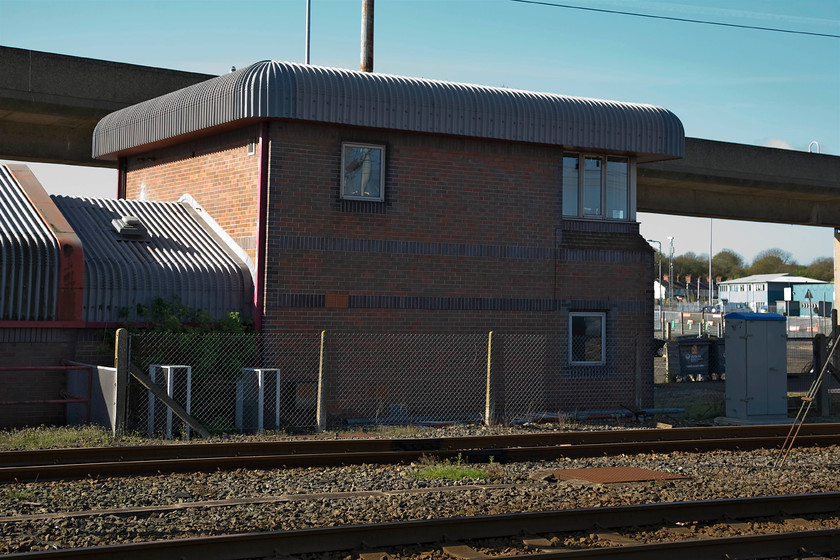 Parkeston signal box (BR, 1987) 
 The rather unusual design of Parkeston signal box is of its time I suppose dating from 1987. This BR built structure replaced a number of boxes in the area as BR desperately tried to save money on this rather under-used branch line now dubbed the Mayflower Line. The large concrete structure passing behind the box carries vehicles on to the vast cross channel ferries that dock directly behind where I am standing as can be seen in the next photograph. 
 Keywords: Parkeston signal box BR 1987