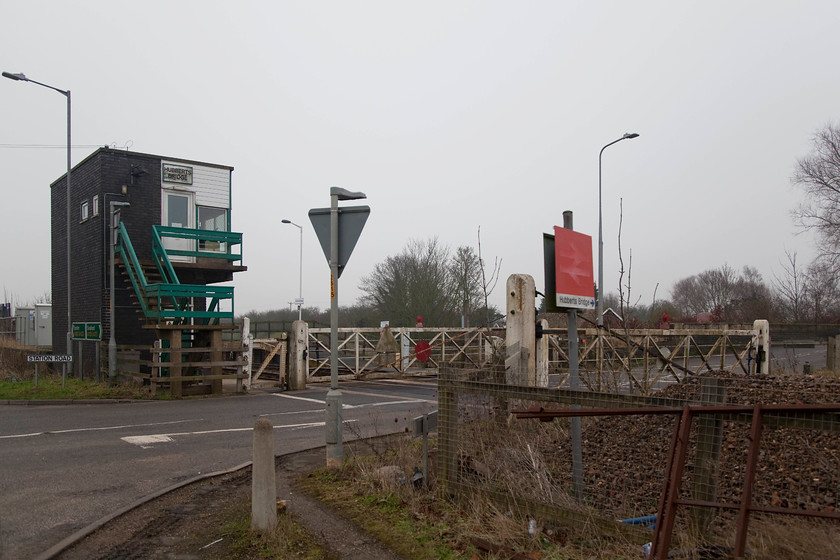 Hubberts Bridge Signal Box (BR, 1961) & crossing gates 
 A reverse view of Hubberts Bridge station, signal box and crossing gates. The dismal weather really adds to this scene. Whenever I visit this part of the country I always get the feeling of going a bit into the wilderness, and I don't mean that offensively to residents of the Fens! 
 Keywords: Hubberts Bridge Signal Box (BR, 1961) & crossing gates