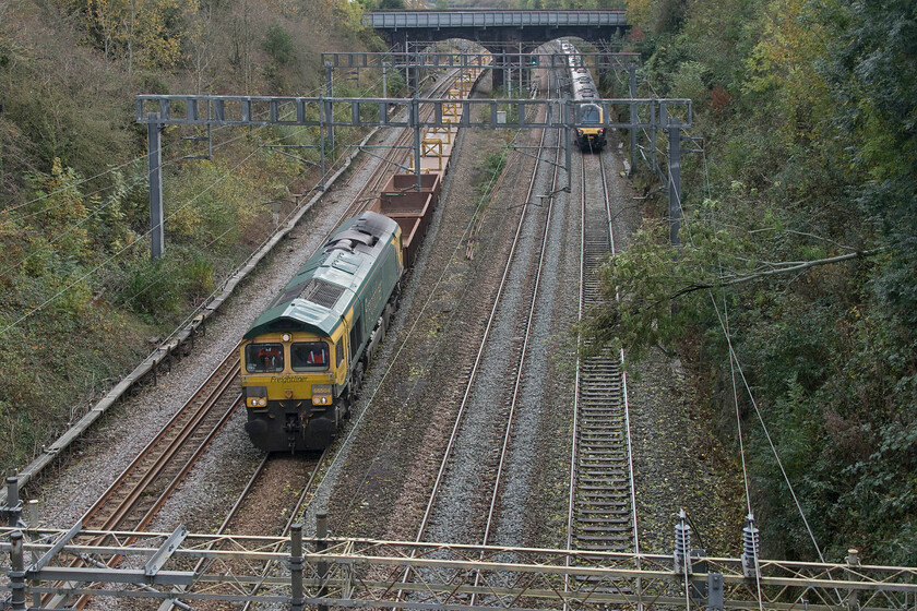 66504, 12.05 Bletchley Relief-Bescot (6Y66, 113L), Hyde Road bridge 
 With its tail lights illuminated 221106 will head back south on the up line in order to clear the obstruction of the ash tree laying on the catenary. Meanwhile, in an effort to clear the engineering blockade on the slow lines to allow passenger traffic to run there was quite a rush to clear the lines and return them for traffic. 66504 heads north past Roade leading the 6Y66 12.05 Bletchley to Bescot engineering train. 
 Keywords: 66504, 12.05 Bletchley Relief-Bescot 6Y66 Hyde Road bridge Freightliner