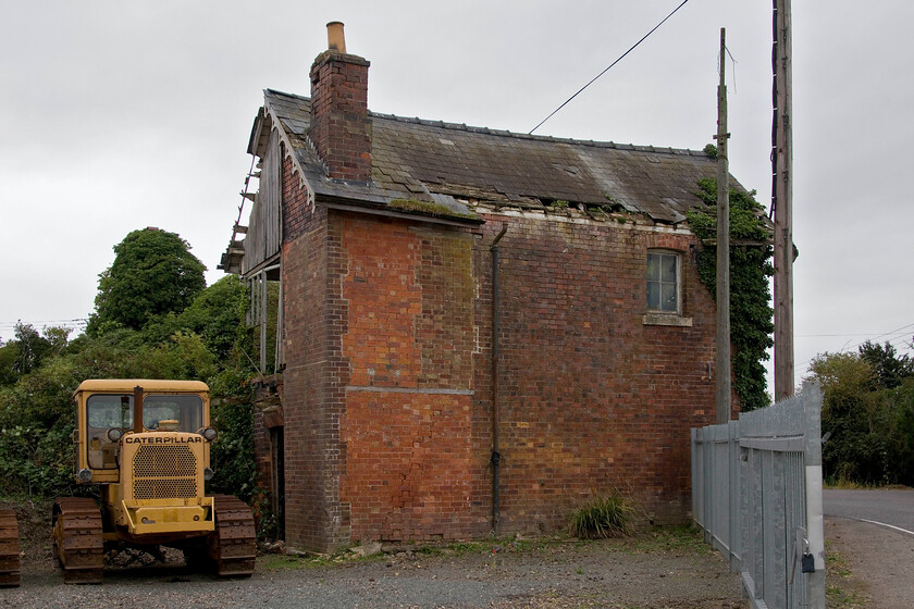 Former Postland signal box (GN, 1882) 
 A view of the rear of the former Great Northern Postalnd signal box dating from 1882. It remains in a dreadful state looking as if the roof will collapse at any time with the brickwork not far behind. It is really in desperate need of somebody taking it on and dismantling it brick by brick to then rebuild it in all its original glory. Is that brave person out there I wonder? Notice the 1967 Caterpillar D6C 82A Agricultural Crawler for sale in the yard of Fenland Tractors, I wonder if they might be able to restore the box? 
 Keywords: Former Postland signal box GN