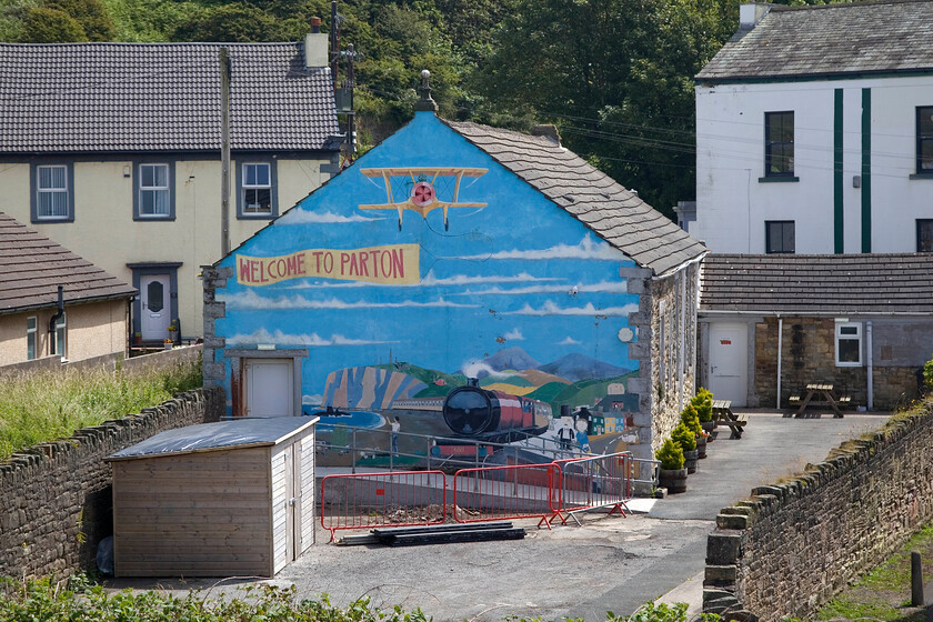 Mural, Parton 
 Parton is a small settlement nestled on the coast between Workington and Whitehaven. It has a small station that has a regular service in both directions towards either Carlisle or Barrow. Whilst standing on the platform, I noticed this impressive mural on the rear wall of the appropriately named Station Inn. I am not sure what the steam locomotive pictured is but it's nice to see. The U-boat is a nod to the infamous attack on the village and its surrounds that took place on 15.08.1915 causing little damage despite the Germans reporting complete destruction. The reason for the attack was in an effort to destroy the nearby village of Lowca where a mine had been opened up to extract benzene and other chemicals, such as toluene (a vital ingredient of TNT) from coal. 
 Keywords: Mural Parton