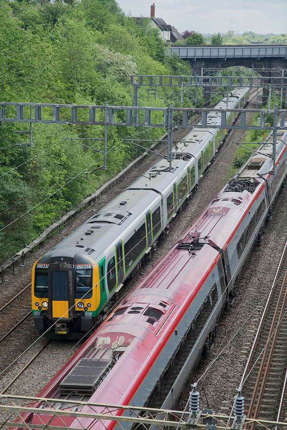 350238 & 350237, LM 11.24 London Euston-Birmingham New Street (2Y11, 8L) & 390127, VT 11.50 Birmingham New Street-London Euston (1B15, 2E), Hyde Road Bridge 
 London Midland 350238 and 350237 pass through Roade and are about to enter the fabled cutting with the 11.24 Euston to New Street. The Desiro is being overhauled by Virgin 390127 'Virgin Buccaneer' also heading for New Street but having left Euston at 11.50, it will also get there a lot sooner than the class 350. 
 Keywords: 350238 350237 2Y11 390127 1B15 Hyde Road Bridge