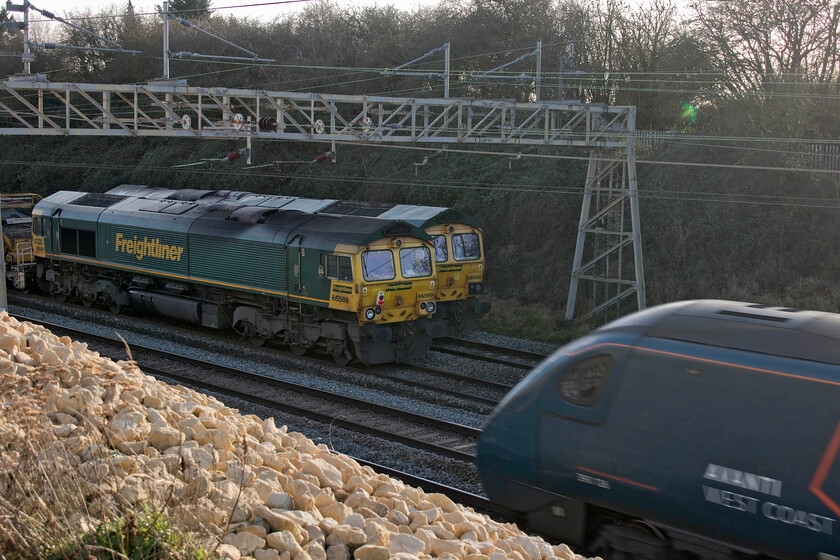 66568, Crewe Basford Hall-Crewe Basford Hall (6Y10), 66569, Crewe Basford Hall-Crewe Basford Hall return (6Y11) & 390126, VT 09.34 Glasgow Central-London Euston (1M05, 1L), Ashton Road bridge 
 Whilst 66568 and 66569 sit switched off on the up and down fast lines between Roade and Ashton 390126 passes on the up slow line working the 09.34 Glasgow Central to Euston. The Pendolino was diverted from its usual route due to engineering work that the two infrastructure trains seen here were supporting. Rather than the more common Sunday closure as it would appear the engineering possession was part of a ten-day scheme to undertake various work on the Weedon line taking full advantage of the much reduced COVID timetable. 
 Keywords: 66568 6Y10 66569 Crewe Basford Hall 6Y11 390126 09.34 Glasgow Central-London Euston 1M05 Ashton Road bridge.jpg