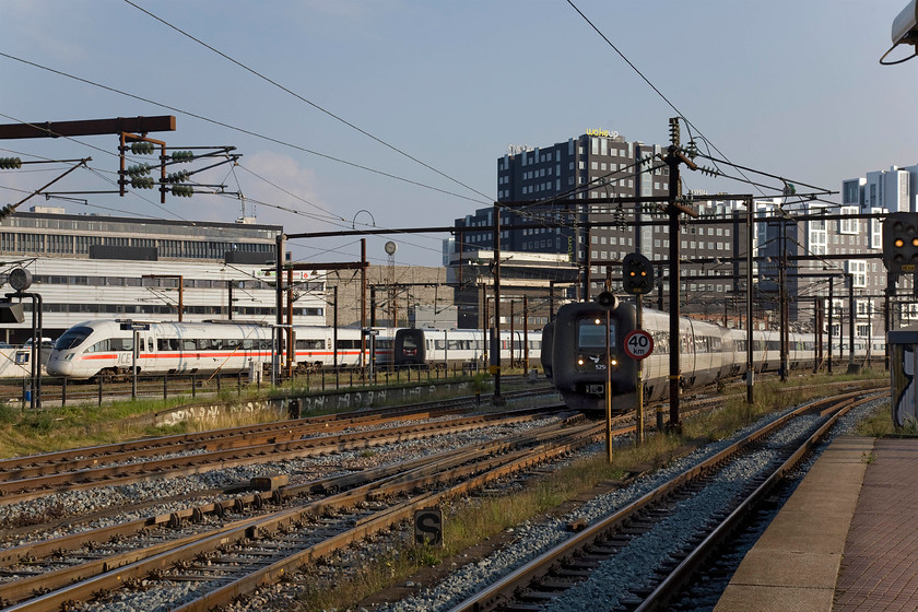 5505, 13.12 Berlin-Copenhagen Central, 5275 & 5250, unidentified workings, Copenhagen Central station 
 A busy evening scene to the southern end of Copenhagen central station. On the far side, a Class 605 ICE service arrives from Germany as the 13.12 Berlin to Copenhagen Central. This unit, 5505, is jointly operated by DB and DSB and will have travelled on the Scandlines ferry to get from Puttgarden to Rdby over the Ostee from mainland Europe to Scandinavia. In the foreground, two IC3s work unidentified services. To the left is set XX75 'The Soldier' and to the right is set XX50 'Poul Due Jensen'. 
 Keywords: 5505 13.12 Berlin-Copenhagen Central 5275 5250 Copenhagen Central station