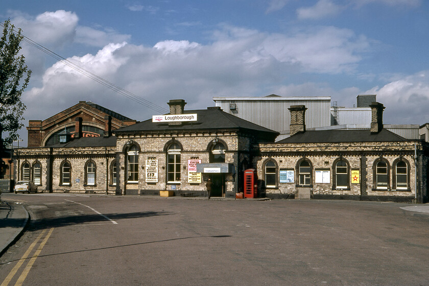 Frontage, Loughborough station 
 Dominated by the Brush factory in the background Loughborough's station frontage is a little dwarfed. This 1872 building replaced an earlier station dating from 1840. The reconstruction was in association with the quadrupling of the track from Leicester. The station is Grade II listed despite that its canopies had been cut back many years before. Notice just one car in the car park and that is our trusted Austin 1100! This view remains very similar today if one ignores the huge changes to the car parking, see.... https://www.ontheupfast.com/p/21936chg/30049461111/x8-frontage-loughborough-station 
 Keywords: Frontage Loughborough station