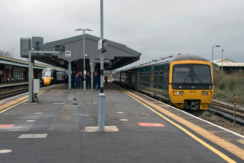 164132 & 165136, GW 11.11 Weymouth-Gloucester (2V64, 1L) & 800307, GW 10.55 Paignton-London Paddington (1A81, RT), Westbury station 
 I had in my head the idea to recreate a photograph that took standing in a very similar spot back in 1976, see..... https://www.ontheupfast.com/p/21936chg/24049434804/x1111-class-50-westbury-station . However, back then, over forty-five years ago, the motive power was somewhat different with a Thumper and a Hoover in-shot but apart from that the similarities at pretty clear to see! In the 2022 view 164132 and 165136 are seen to the right leaving with the station working the 2V64 11.11 Weymouth to Gloucester service whilst to the left 800307 arrives working the 10.55 Paignton to Paddington train. 
 Keywords: 164132 165136 11.11 Weymouth-Gloucester 2V64 800307 10.55 Paignton-London Paddington 1A81 Westbury station