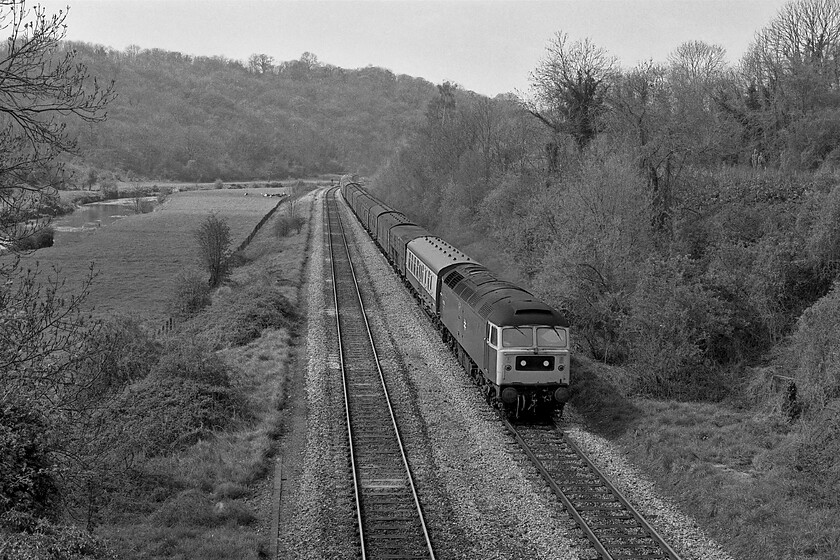 Class 47, up diverted vans, Avoncliff aqueduct 
 A long train of mixed vans passes along the Avon Valley on the approach to Avoncliff with the picture taken from the village's famous aqueduct that carries the Kennet and Avon canal across the valley. Unfortunately, I do not have the number of the Class 47 leading the train but it is the consist that is of more interest with a variety of van types that includes a Syphon G, LMS and Southern vans amongst the more recent Mk. 1 and other standard derivatives. 
 Keywords: Class 47 diverted vans Avoncliff aqueduct