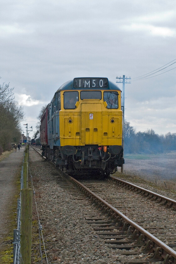 31289, 11.00 Pitsford & Brampton return, between Bridge 13 & Merry Tom Lane 
 Leaving a blue exhaust haze in its wake resident 'dirty diesel' 31289 approaches Merry Tome Lane on the Northampton and Lamport Railway with the 11.00 return Easter special. I am not sure why the driver has chosen 1M50 as the headcode on display as it is usually assigned to an international service from the south coast to the Midlands; not a working usually associated with Class 31s. Alternatively, it could have been to celebrate 31289's half-century but this important birthday took place two years ago in 2011! 
 Keywords: 31289 11.00 Pitsford & Brampton return Bridge 13 Merry Tom Lane A1A-A1A Type 2 Class 31