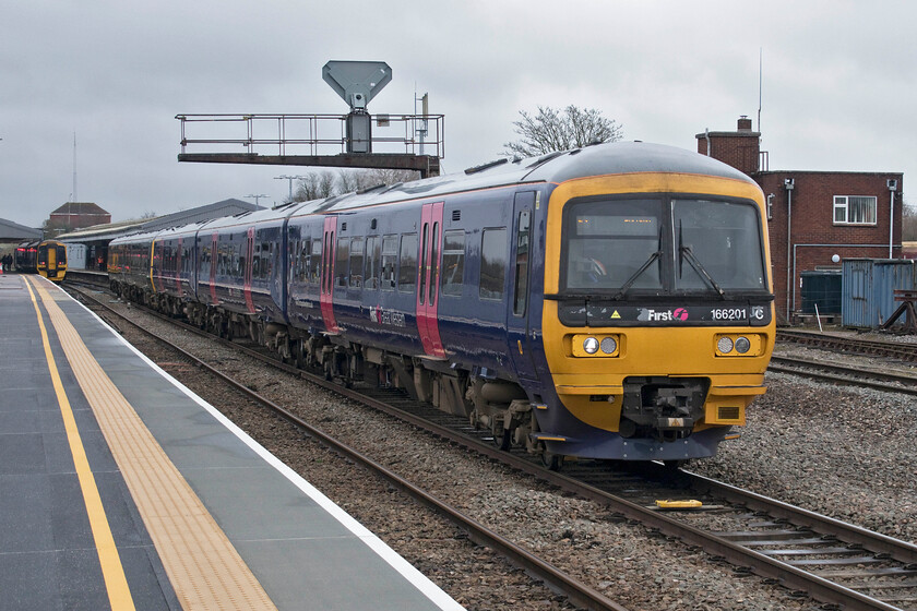 166201 & 165134, GW 10.30 Cardiff Central-Portsmouth Harbour (1F13, 2L) & 158765, GW 12.17 Westbury-Swindon (2M17, 4L), Westbury station 
 With 166201 still wearing its First Great Western livery, it looks from the peeling paint of the front end that it is ready to enter the shop for a much-needed repaint. It leads 165134 away from Westbury working the 10.30 Cardiff Central to Portsmouth Harbour service. On platform two the 12.17 local service to Swindon will soon depart worked by 158756. 
 Keywords: 166201 165134 10.30 Cardiff Central-Portsmouth Harbour 1F13 158765 12.17 Westbury-Swindon 2M17 Westbury station Turbo GWR