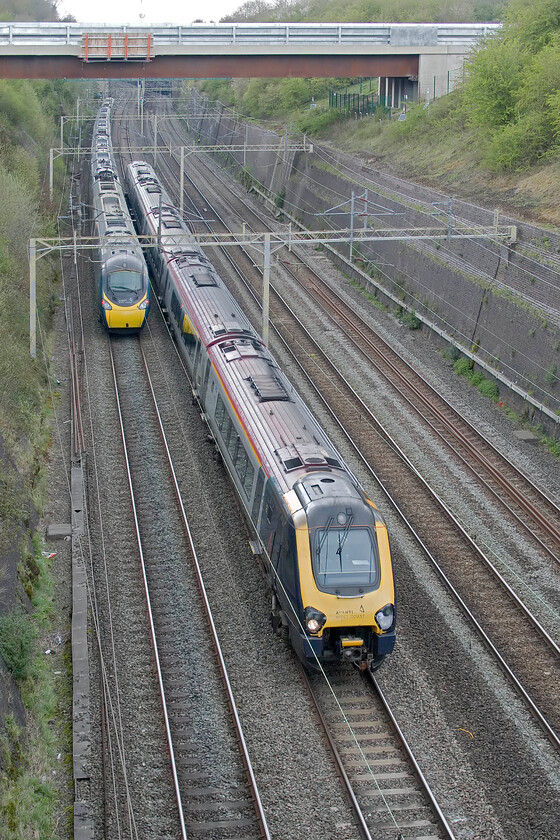 221110, VT 12.06 Wrexham General-London Euston (1A28, 16L) & 390154, VT 13.32 London Euston-Manchester Piccadilly (1H68, 10L), Roade cutting 
 This appears to be a perfectly normal scene in Roade cutting but looks can be deceiving! Both Avanti services were running at barely walking pace, as were all trains on the fast line in the vicinity. All up services were being Brought to a halt at the signal just beyond the bridge in this view, held and then permitted to move to the next signal. At one point 221110 working the 1A28 12.06 Wrexham to Euston was held in full view of the proceeding Pendolino held at the next signal. This went on for some time with all trains picking up considerable delays with northbound trains also being delayed but less so. 390154 is seen working the 13.32 Euston to Manchester service on the down fast line. 
 Keywords: 221110 12.06 Wrexham General-London Euston 1A28 390154 13.32 London Euston-Manchester Piccadilly 1H68 Roade cutting AWC Avanti West Coast Pendolino Voyager