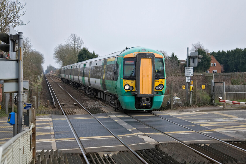 377144, SN 13.02 London Victoria-Portsmouth Harbour, Nutbourne station 
 Nutbourne station is one of a number that comes thick and fast between Havant and Chichester on the Coastway route. 377144 passes the level crossing just to the east of the platform ends working the 13.02 Victoria to Portsmouth Harbour 'fast' service. 
 Keywords: 377144 13.02 London Victoria-Portsmouth Harbour Nutbourne station Southern Electrostar